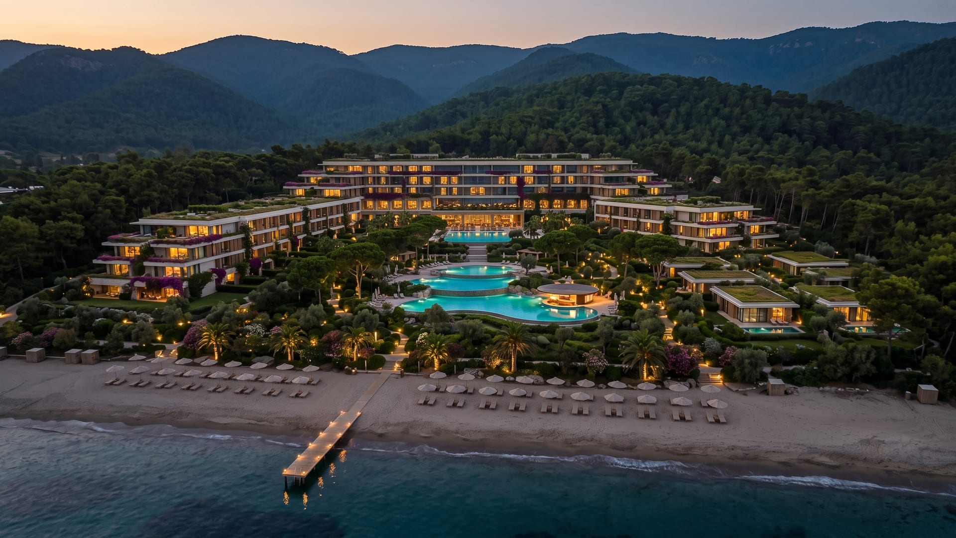 Alacakaranlıkta ışıkları yanan ana bina ve basamaklı havuzlar
